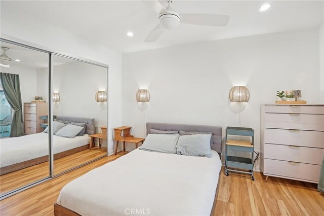 bedroom featuring ceiling fan, light hardwood / wood-style floors, and a closet