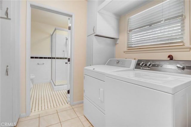 laundry room with light tile patterned floors and washing machine and clothes dryer