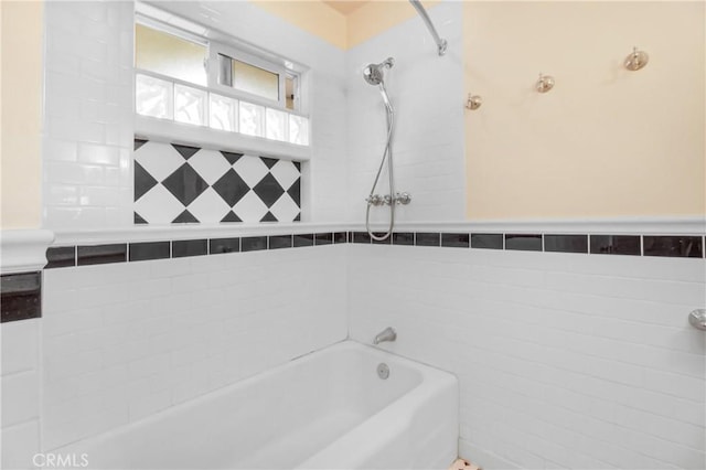 bathroom with tile walls and tiled shower / bath combo