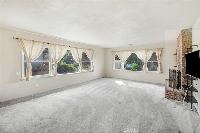 unfurnished living room featuring a brick fireplace and carpet