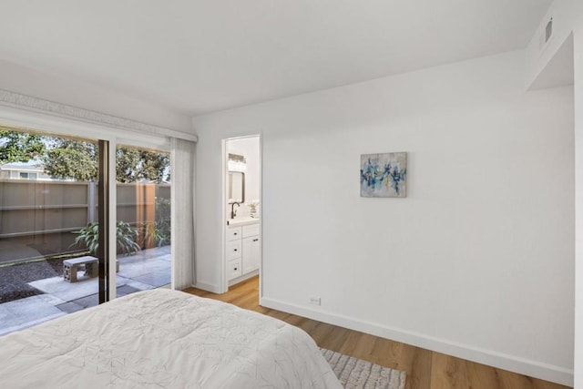 bedroom with light hardwood / wood-style floors and ensuite bath