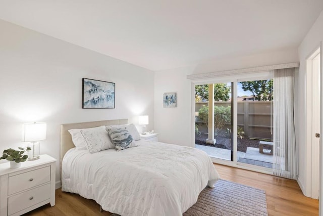 bedroom with access to exterior and hardwood / wood-style floors