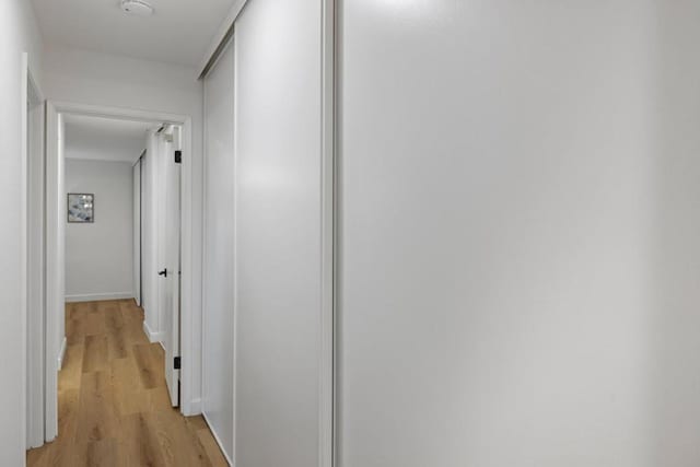 corridor with light hardwood / wood-style floors