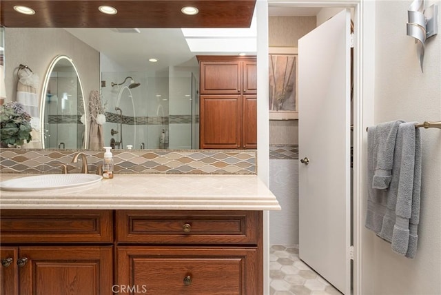 bathroom with vanity, tile patterned floors, tasteful backsplash, and a shower with door