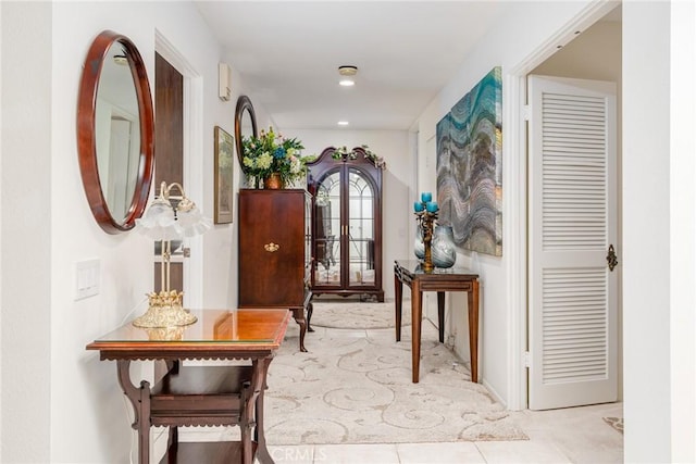 corridor featuring light tile patterned floors and french doors