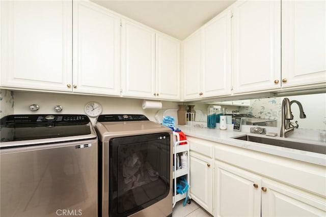 clothes washing area featuring cabinets, light tile patterned flooring, independent washer and dryer, and sink