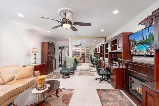 home office featuring light carpet and ceiling fan