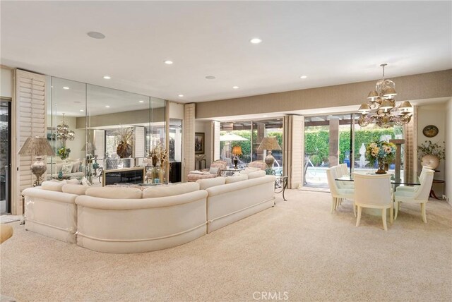 carpeted living room featuring a notable chandelier