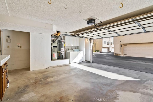 garage with water heater, a carport, washing machine and clothes dryer, a garage door opener, and heating unit