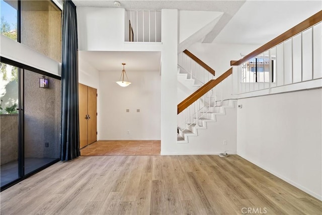 foyer entrance with a towering ceiling and light hardwood / wood-style flooring