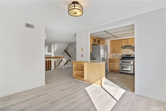 kitchen featuring backsplash, light wood-type flooring, stainless steel appliances, light brown cabinetry, and light stone counters