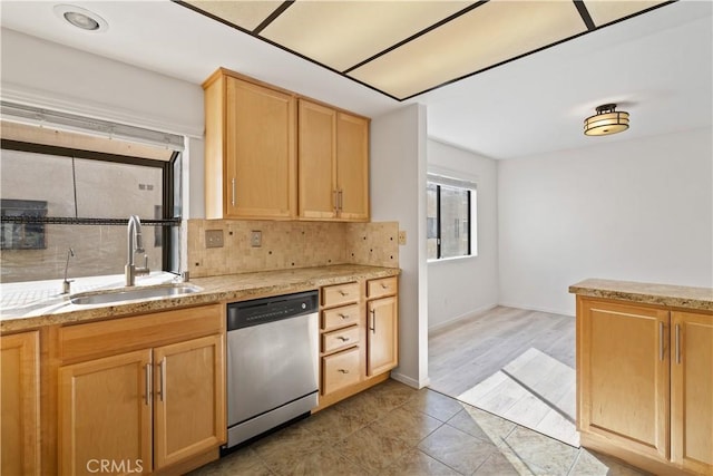 kitchen featuring light tile patterned floors, tasteful backsplash, light brown cabinetry, stainless steel dishwasher, and sink