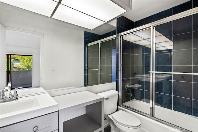 full bathroom with combined bath / shower with glass door, vanity, and toilet