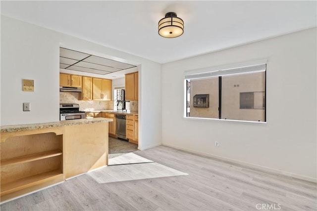 kitchen featuring light wood-type flooring, appliances with stainless steel finishes, backsplash, and light brown cabinets