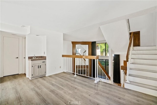 unfurnished room with light hardwood / wood-style floors and sink