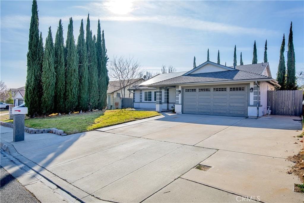 ranch-style home with a garage and a front yard