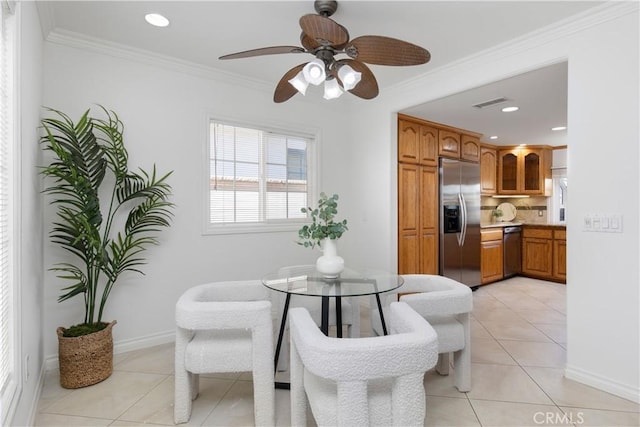 tiled dining room with ceiling fan and ornamental molding