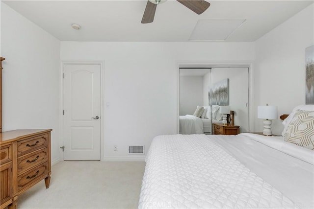 bedroom with ceiling fan, a closet, and light carpet