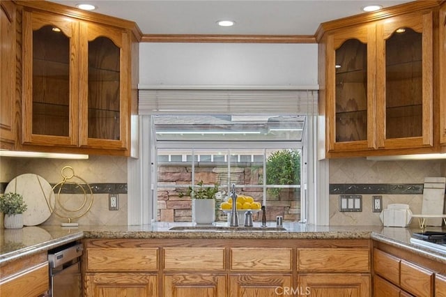 kitchen with ornamental molding, dishwasher, tasteful backsplash, and sink