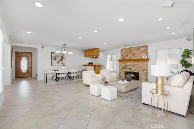 living room featuring a wealth of natural light, ornamental molding, and a stone fireplace