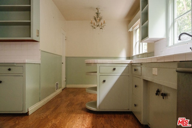 kitchen with an inviting chandelier, backsplash, dark hardwood / wood-style floors, and tile countertops