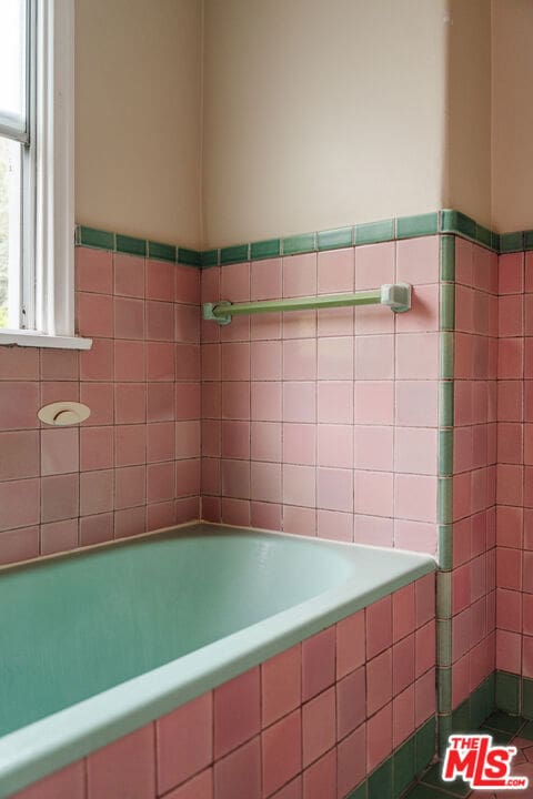 bathroom featuring a relaxing tiled tub