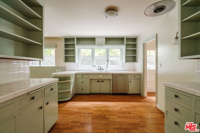 kitchen featuring tile counters, backsplash, dishwasher, and light hardwood / wood-style flooring