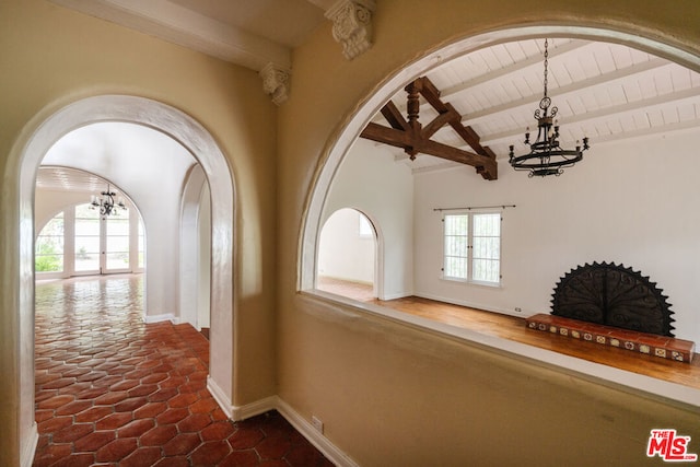 hallway with wooden ceiling, a healthy amount of sunlight, and vaulted ceiling with beams