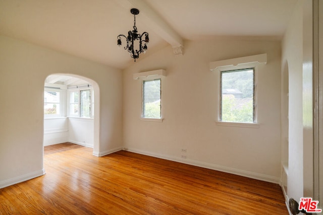 unfurnished room featuring vaulted ceiling with beams, an inviting chandelier, and light hardwood / wood-style floors