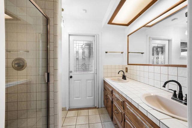 bathroom with tile patterned flooring, a shower with shower door, and decorative backsplash