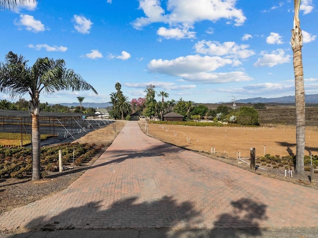 view of street with a rural view and a mountain view