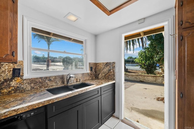 kitchen featuring light tile patterned flooring, dishwasher, backsplash, and sink