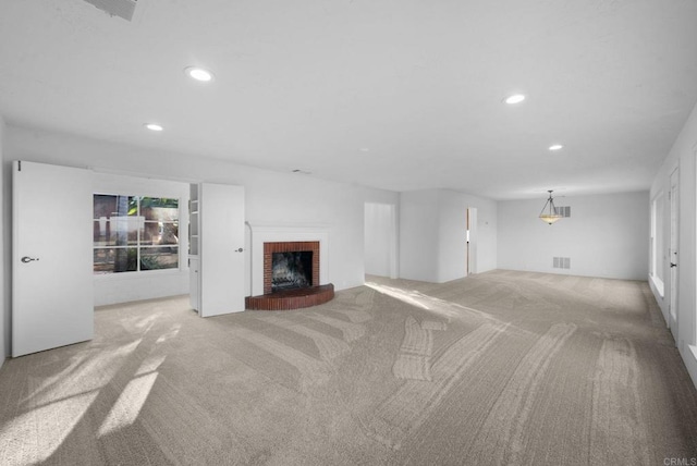 unfurnished living room with light colored carpet and a fireplace