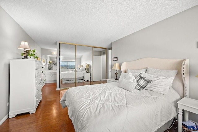 bedroom featuring dark wood-type flooring, a closet, and a textured ceiling