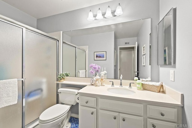 bathroom featuring vanity, a shower with door, and toilet