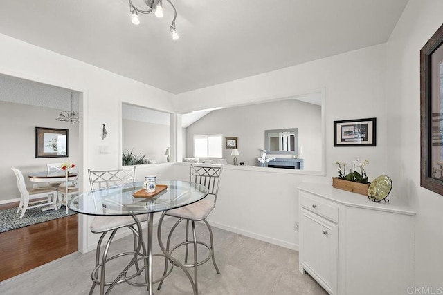 dining space with a chandelier and vaulted ceiling