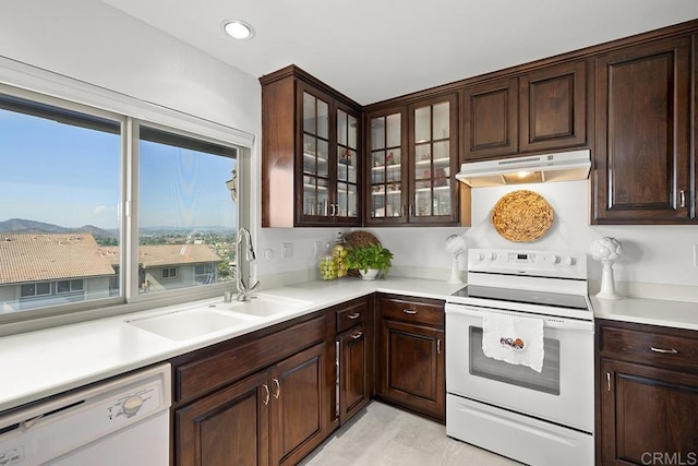 kitchen featuring white appliances, a mountain view, sink, and a wealth of natural light