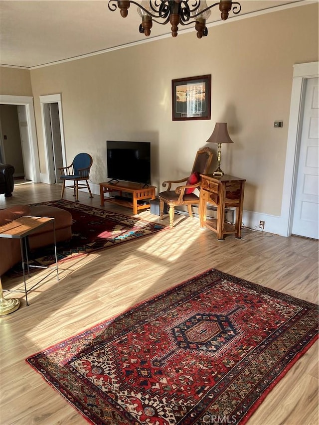 living room with hardwood / wood-style flooring, crown molding, and a chandelier