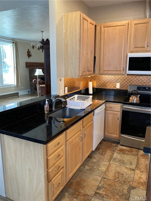 kitchen featuring tasteful backsplash, light brown cabinetry, sink, and white appliances