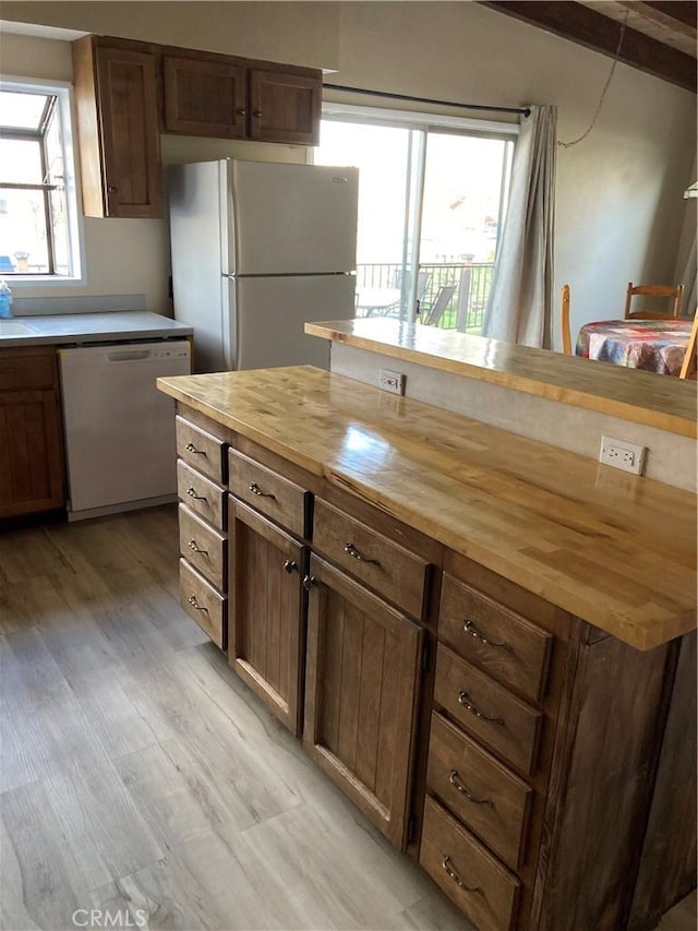 kitchen featuring butcher block counters, light hardwood / wood-style floors, a center island, and white appliances