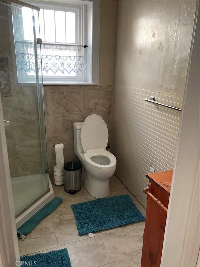 bathroom featuring toilet, a shower with door, vanity, and tile patterned flooring