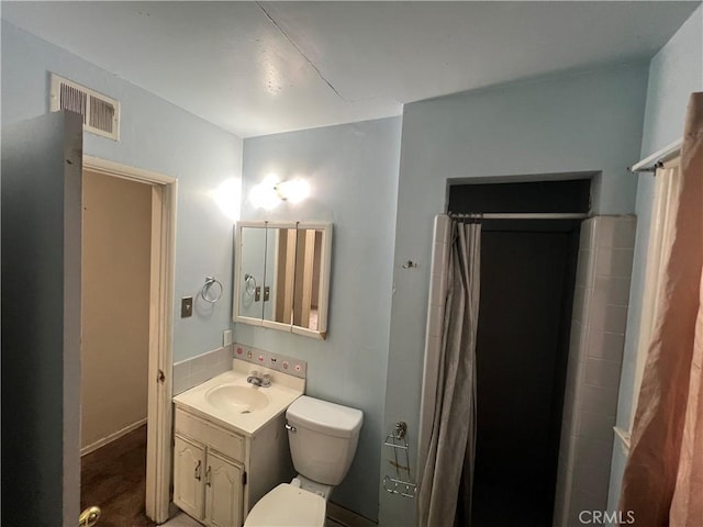 bathroom featuring toilet, vanity, and a shower with shower curtain