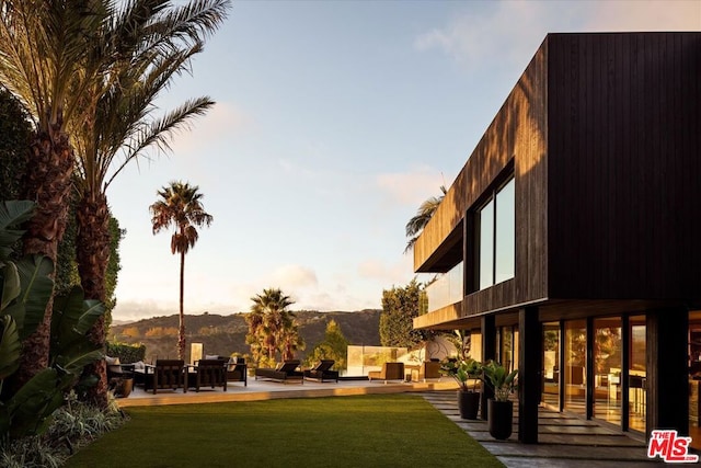 view of home's community with a lawn, a patio area, and a mountain view