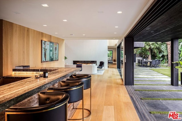 bar with wood walls and light wood-type flooring