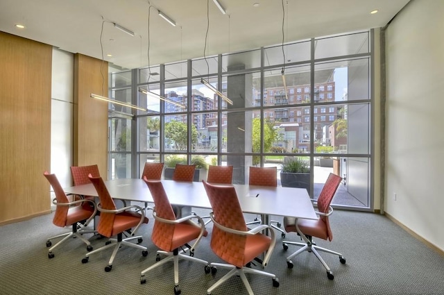 carpeted dining room featuring a wall of windows and wooden walls