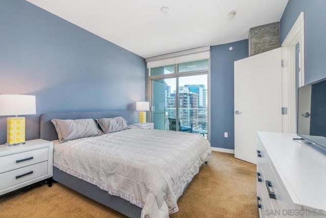 bedroom with floor to ceiling windows and light carpet