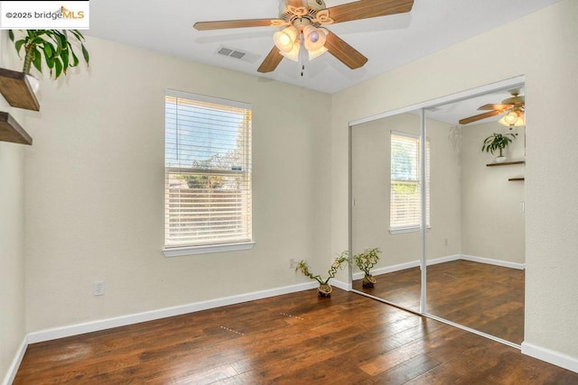 unfurnished bedroom with ceiling fan, a closet, and dark hardwood / wood-style floors