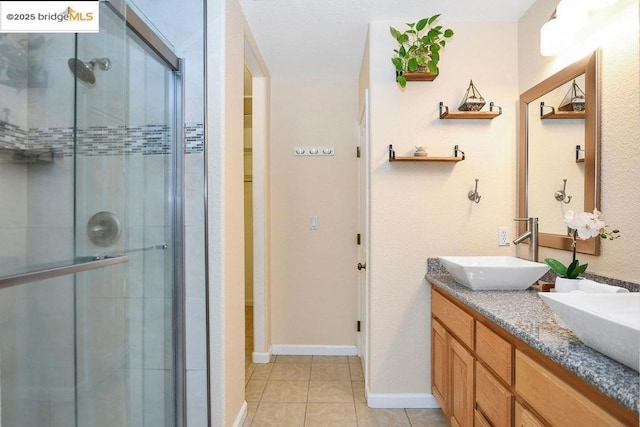 bathroom with walk in shower, vanity, and tile patterned flooring