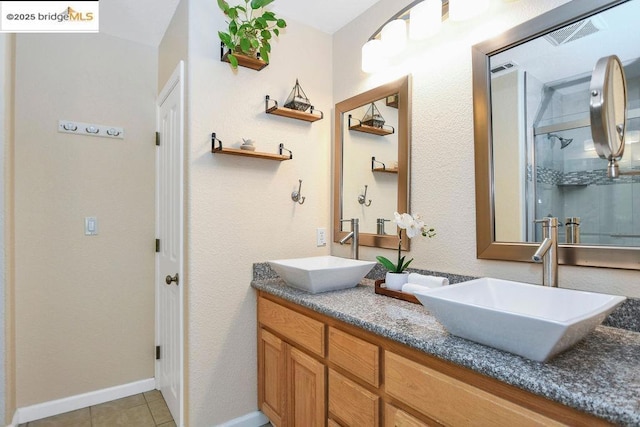 bathroom with tile patterned flooring, a shower with shower door, and vanity