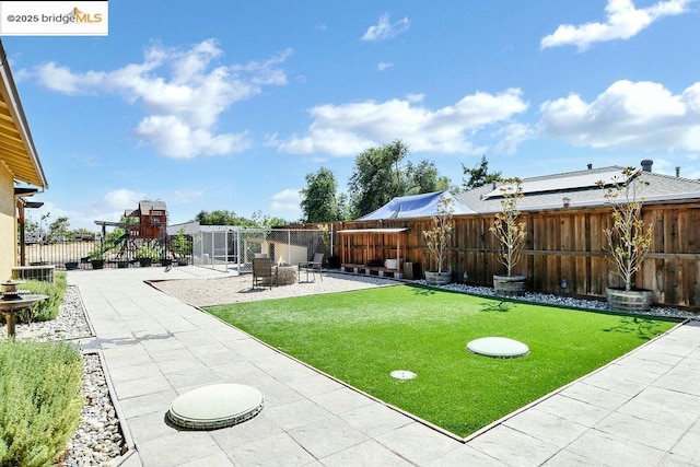 view of yard featuring a playground and a patio